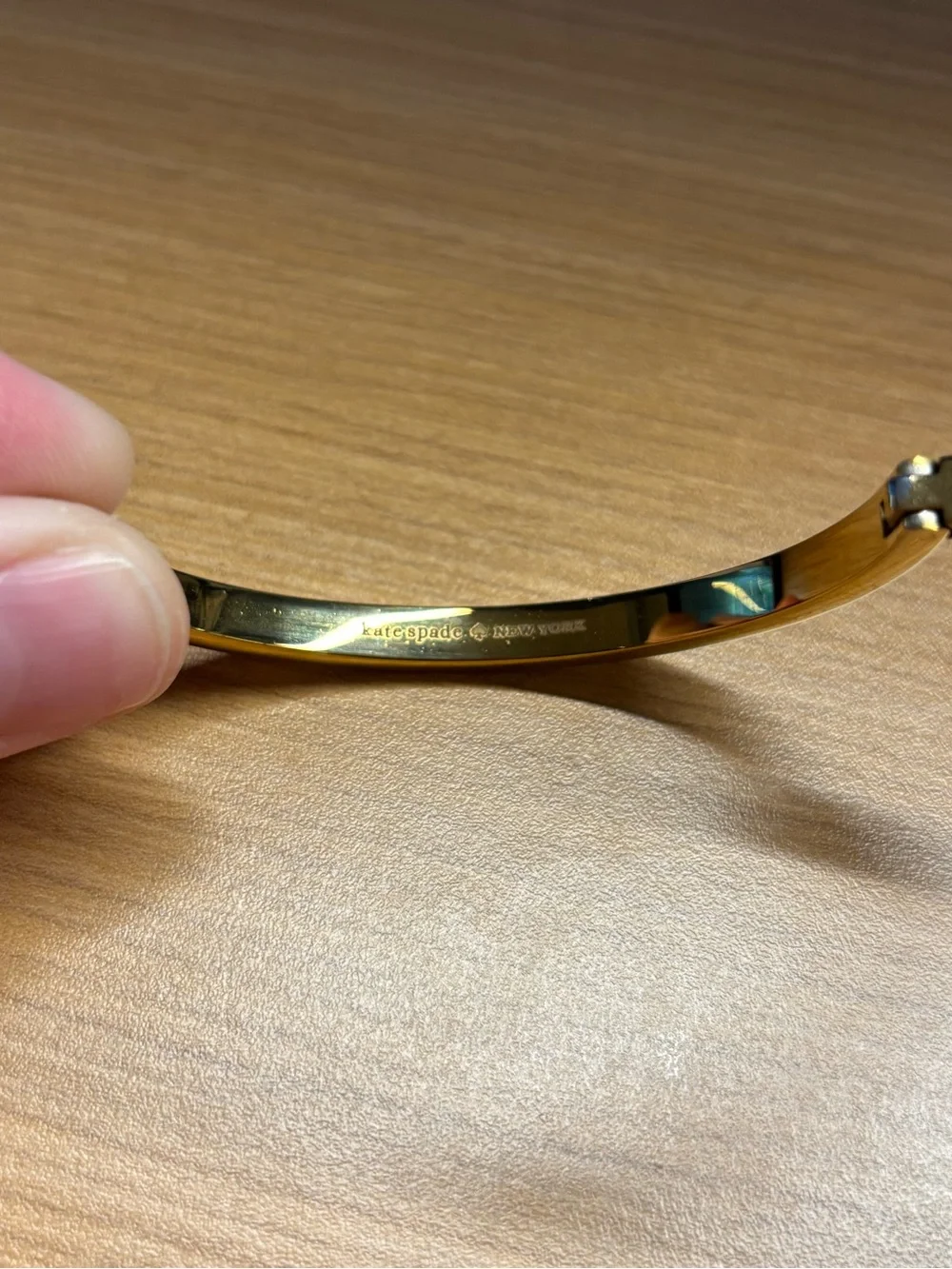 Kate Spade gold-tone hinged bangle featuring inset crystal accents